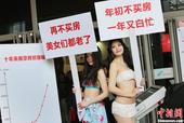 4月19日，在南京举办的2013春季房地产商品交易会上，两位泳装模特举出“再不买房，美女们都老了”、...